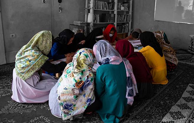 2022년 8월 아프가니스탄 카불의 비밀 학교에서 수업을 듣는 여학생들.  재집권 이후 탈레반은 여성의 중등 및 고등교육을 금지했다.