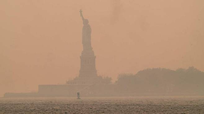 7일 뉴욕 자유의 여신상이 짙은 산불 연기에 휩싸여 있다. 뉴욕/AFP 연합뉴스