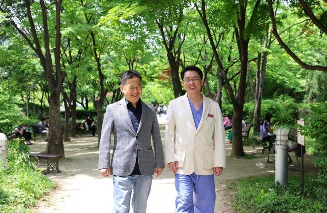 김용덕 씨(왼쪽)는 15년 동안 확장성심근병증으로 고생하다 지난해 11월 심장 이식 수술 후에 완치됐다. 김 씨가 수술을 담당했던 조양현 삼성서울병원 심장외과 교수와 함께 병원 산책로를 걷고 있다. 삼성서울병원 제공