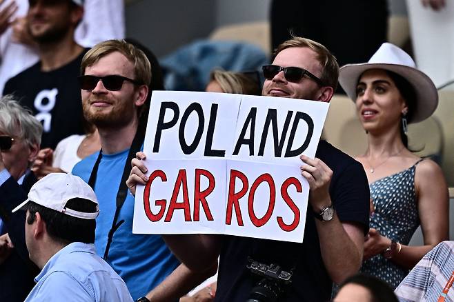 이가 시비옹테크의 한 팬이 10일(현지 시각) 프랑스 파리에서 열린 프랑스오픈 여자 단식 결승전에서 프랑스오픈의 또 다른 명칭인 '롤랑 가로스(Roland Garros)' 대신 언어유희가 가미된 '폴란드 가로스(Poland Garros)'가 적힌 종이를 들고 응원하는 모습. /AFP연합뉴스