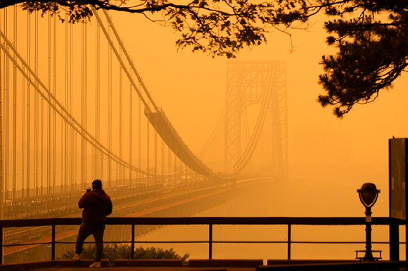 6월 7일(현지시간) 미 뉴저지주 포트리에서 한 남성이 캐나다 산불로 오염된 대기 속 조지 워싱턴 다리를 바라보며 전화 통화를 하고 있다. [사진=AP/뉴시스]