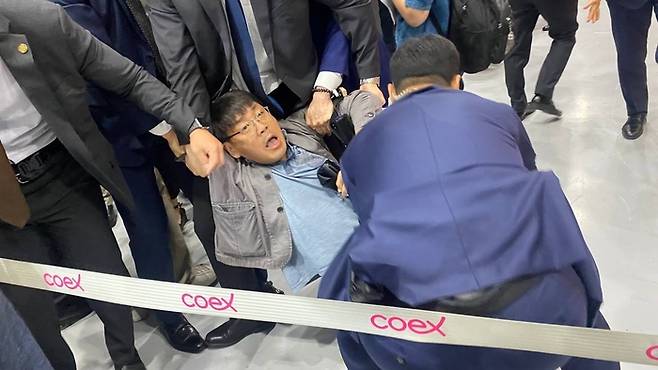 14일 개막한 서울국제도서전에서 송경동 시인이 대통령경호법을 위반했다는 이유로 끌려나가는 모습. 송경동 시인 제공