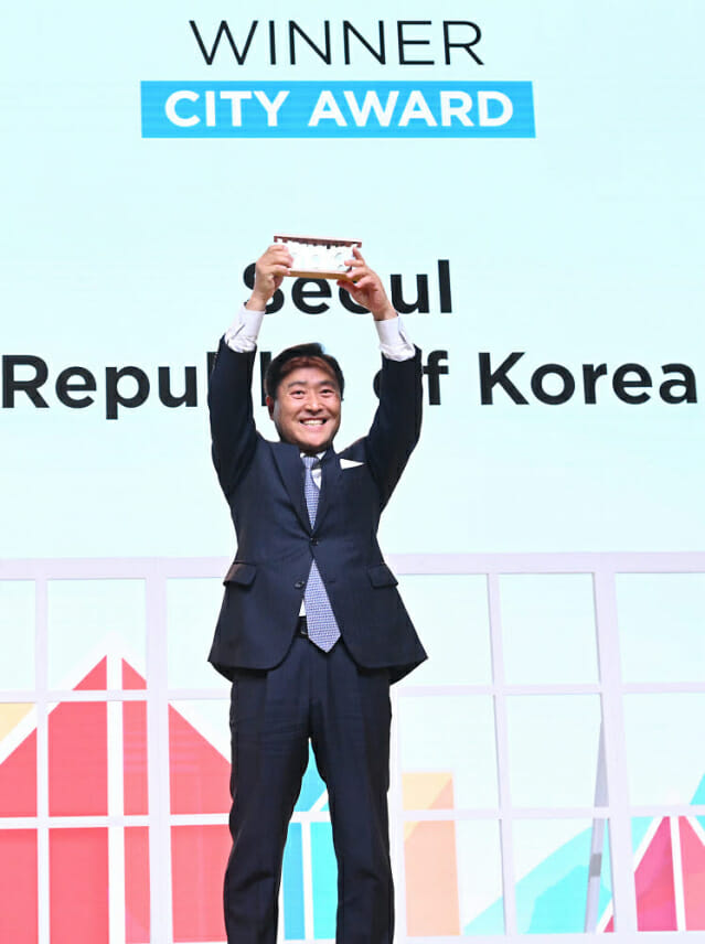 강요식 이사장이 지난 11월 스페인에서 열린 'SCEWC 2022'에서 최우수 도시상을 수상한 서울시 상패를 들어올리고 있다.