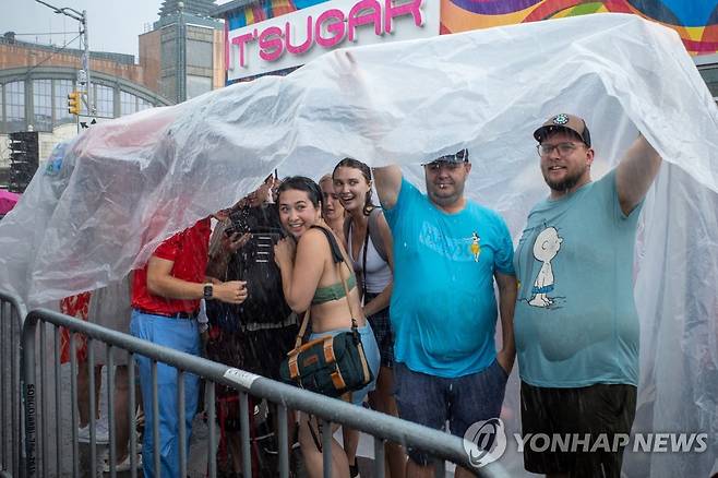 폭우 속에서도 해산하지 않는 관중 (뉴욕 UPI=연합뉴스) 뉴욕 핫도그 먹기 대회 행사장 주변에서 비를 피하는 관중. 2023.7.4 photo@yna.co.kr