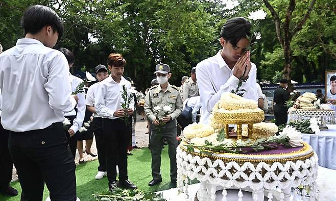 10일 ‘동굴 생환’ 5주년 기념식에 참석한 이들이 자신들을 구조하다가 숨졌 태국 해군 특수부대원의 영정에 헌화하고 있다. 치앙라이=AFP연합뉴스