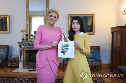 윤석열 대통령 부인 김건희 여사가 13일(현지시간) 폴란드 바르샤바의 영빈관인 벨베데르궁에서 안제이 두다 폴란드 대통령의 부인 아가타 코른하우저 두다 여사에게 바이바이 플라스틱 에코백과 부산엑스포 키링을 선물하고 있다.<연합뉴스>