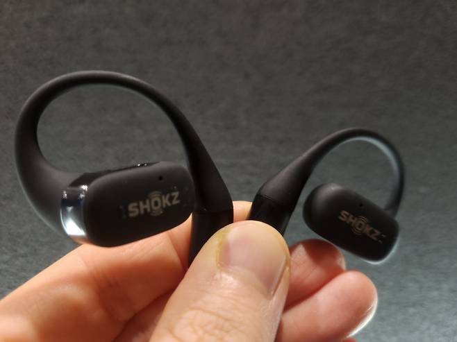 샥즈의 오픈 이어 무선이어폰 ‘오픈핏’. 이어버드 옆 실리콘으로 된 곡선의 이어후크가 귓등을 감싸며 이어버드를 귀 옆에 고정한다. 이영기 기자.