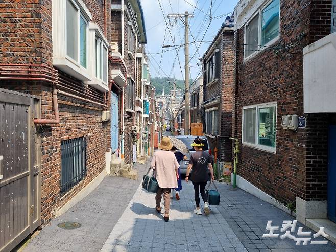 지난 20일 효사랑운동봉사회 김맹임 대표(왼쪽)와 김남은씨가 노인들을 위한 무료 도시락 배달을 위해 성남 태평동 골목길을 걷고 있다. 정성욱 기자