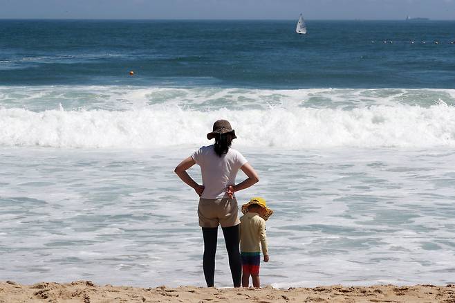 휴가지를 찾은 한 모자(母子)가 바다에 들어가지 못하자 해변에서 파도만 바라보며 아쉬움을 달래고 있다. /남강호 기자