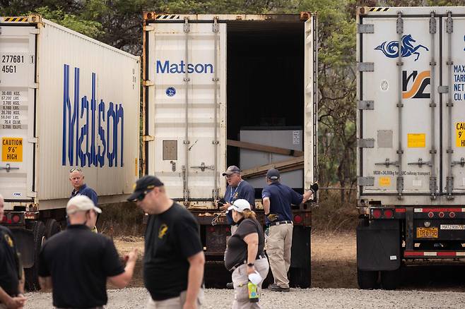 15일(현지 시각) 미국 하와이주 와일루쿠의 마우이 경찰 법의학 시설 옆에 산불 희생자들의 시신을 실은 트럭이 주차돼 있다. 트럭 안 컨테이너엔 "시신 가방 - 성인/청소년/유아"라고 적힌 스티커가 붙어 있다.