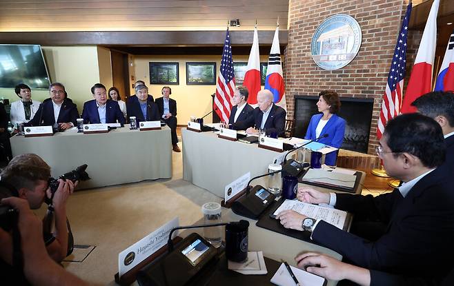 윤석열 대통령(왼쪽 두번째)과 조 바이든 미국 대통령(가운데 탁자 가운데), 기시다 후미오 일본 총리(오른쪽 두번째)가 18일(현지시각) 미국 대통령 별장인 메릴랜드주 캠프 데이비드에서 한·미·일 정상회의를 하고 있다.캠프 데이비드/연합뉴스