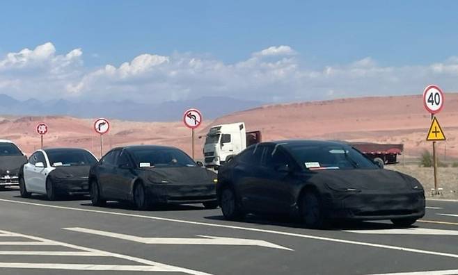 지난 22일 중국 신장웨이우얼 자치구에서 테슬라 모델3 개선 버전인 '하이랜드' 위장막 사진이 포착됐다. 이 사진을 올린 중국 블로거는 차량들이 고온 테스트 중이라고 전했다. /不看车 웨이보