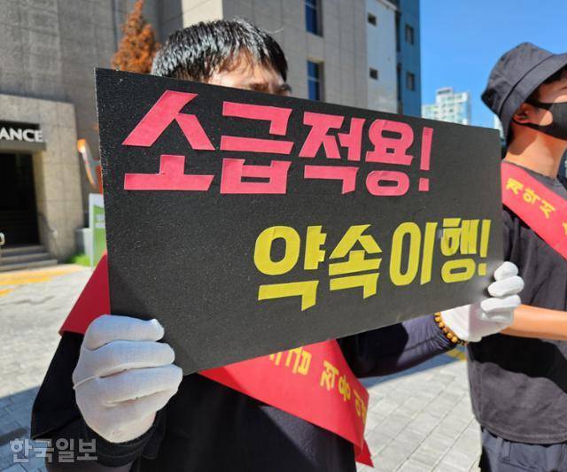 대구 수성구 신축아파트 한 입주민이 지난 26일 아파트 입구에서 '소급적용 약속이행'이 쓰인 피켓을 들고 시공사 측에 항의하고 있다. 입주민 제공