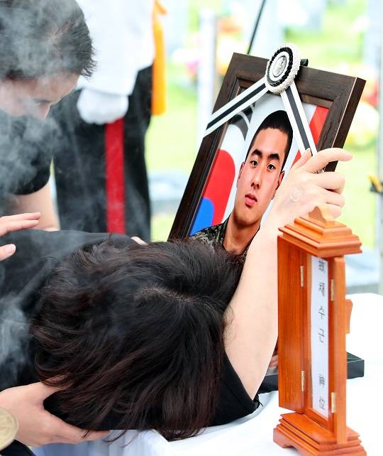 해병대 고 채 상병의 안장식이 지난 7월 22일 오후 대전 유성구 국립대전현충원 장병 4묘역에서 거행된 가운데, 채 상병의 어머니가 아들의 영정 사진을 잡고 오열하고 있다. 출처 뉴스1