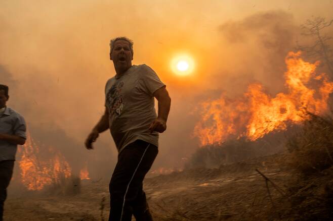 지난 7월25일(현지시각) 산불이 발생한 그리스 로도스에서 대피하는 한 주민. /연합뉴스
