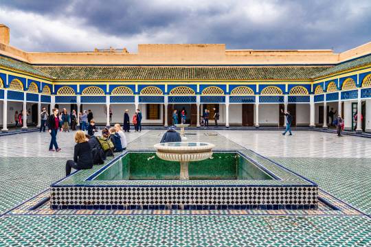 마라케시 바이아 궁전의 아름다운 안뜰. 사진은 역사적인 장소를 방문하는 관광객들을 담고 있습니다.