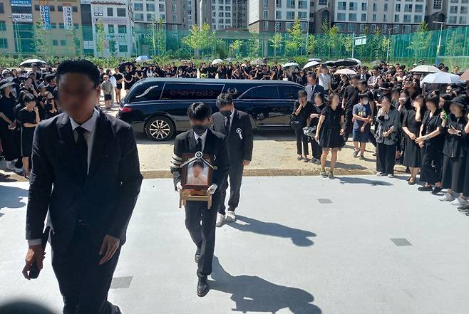 학부모 악성 민원 등에 시달려 극단적인 선택을 한 대전 40대 여교사 운구차량이 9일 근무하던 유성구 한 초등학교에 도착했다. 유족이 운구차량에서 영정사진을 내려 들고 평소 제자들을 가르치던 교실로 향하고 있다. 뉴시스