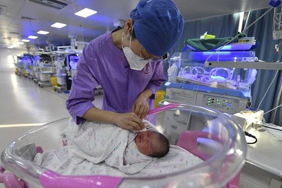 중국의 한 산부인과 병원에서 간호사가 신생아를 돌보고 있다. AP=연합뉴스