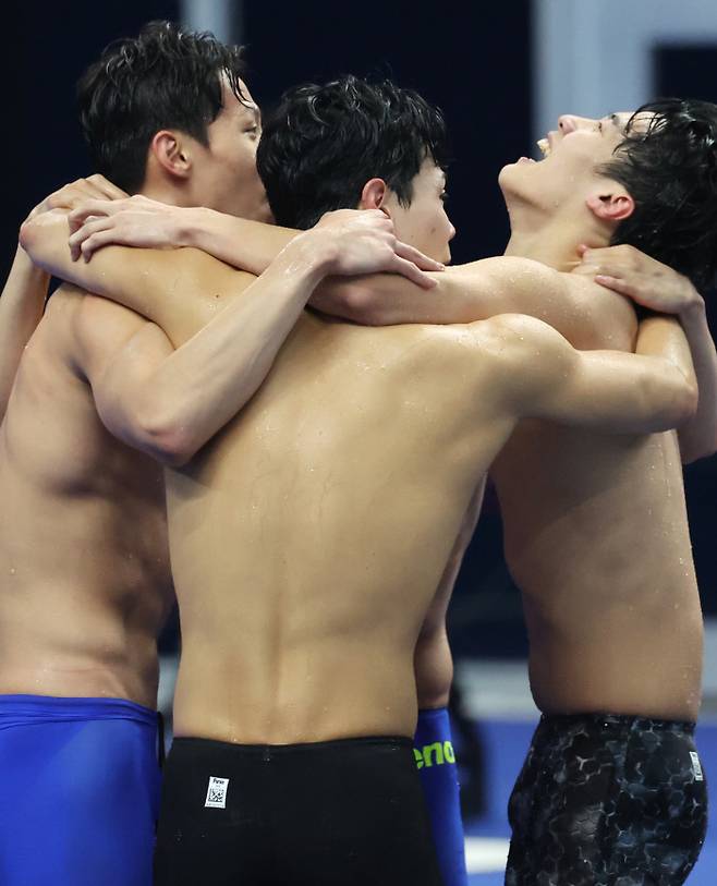 해냈다! 양재훈, 이호준, 김우민(왼쪽부터) 등 한국 남자 수영 대표 선수들이 25일 중국 항저우 올림픽 스포츠센터 수영장에서 열린 항저우 아시안게임 수영 남자 계영 800m 결승에서 마지막 영자 황선우가 가장 먼저 터치패드를 찍으며 금메달을 따내자 함께 얼싸안고 기뻐하고 있다. 항저우 | 연합뉴스