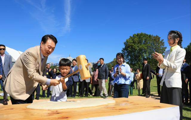 ▲윤석열 대통령과 김건희 여사가 24일 서울 용산어린이정원에서 추석을 앞두고 열린 '추석맞이 팔도장터'를 찾아 어린이와 함께 떡메치기를 하고 있다. ⓒ연합뉴스