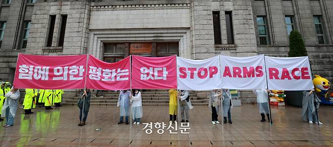 참여연대를 비롯한 시민사회단체 활동가들이 건군 75주년 국군의 날 기념식이 진행된 26일 서울도서관 앞에서 시가행진에 항의하는 현수막을 펼쳐 들고 있다. 조태형 기자