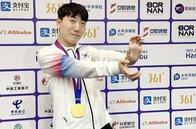 28일 중국 항저우 e스포츠센터에서 열린 2022 항저우 아시안게임(AG) 스트리트 파이터 V 결승전에서 대만의 샹여우린을 세트 점수 4-3으로 물리치고 금메달을 획득한 뒤 공동취재구역(믹스트존)에서 취재진을 향해 포즈를 취하고 있다. 연합뉴스