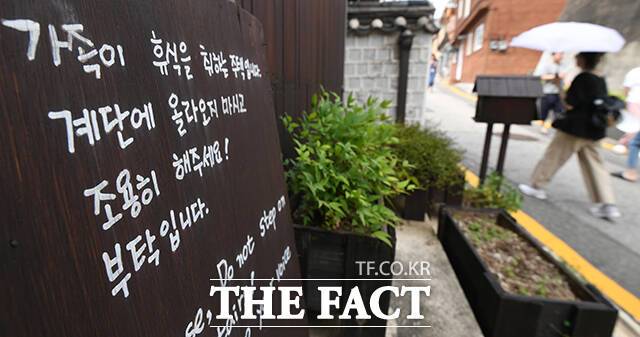 북촌한옥마을 가정집 대문 앞에 정숙을 부탁하는 팻말이 놓여 있다.