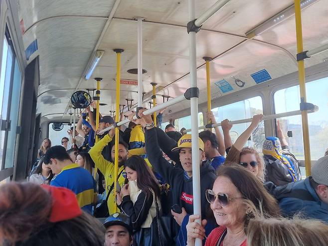 지난 1일(현지 시각) 아르헨티나 수도 부에노스아이레스의 라 봄보네라에서 열린 보카주니어스와 리버플레이트의 '수페르클라시코'로 가는 시내버스에 탑승해 응원가를 부르는 보카주니어스 팬들. /서유근 특파원