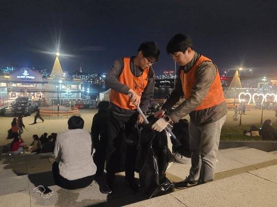 불꽃축제가 종료된 오후 9시 30분, 한화 임직원 봉사단원들이 2인 1조로 주변 쓰레기를 수거하고 있다. 김민정 기자