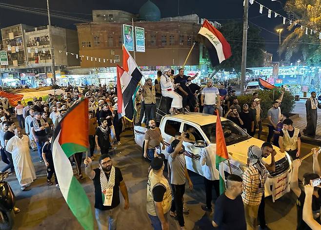 18일 이라크 바그다드에서 팔레스타인 지지 집회에 참석한 시위 참가자들이 팔레스타인 국기와 이라크 국기를 흔들며 행진하고 있다. EPA 연합뉴스