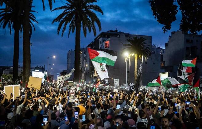 18일 모로코 카사블랑카의 미국 영사관 앞에서 팔레스타인을 지지하는 시위가 이어지며 대규모의 시위 참여자들이 팔레스타인 국기를 흔들고 있다. AFP 연합뉴스
