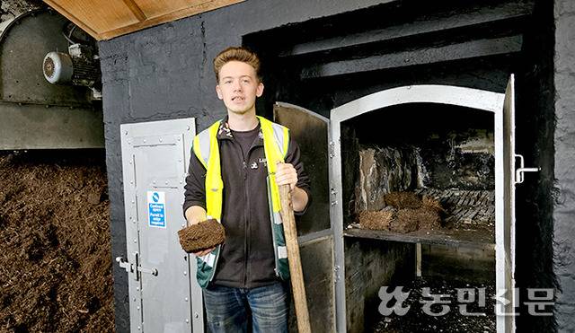 피트 위스키는 몰트를 피트(이탄)로 훈연해 술에 독특한 향을 입혀 만든다. 증류소 직원이 손에 피트를 들고 있다.