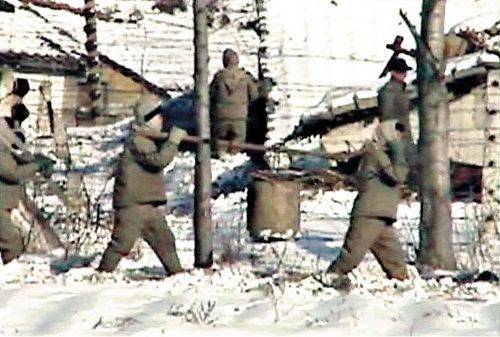 일본 후지TV가 2004년 2월 27일 공개한 북한 함남 요덕정치범수용소 모습. 정치범들이 경비대와 보위부원들의 주택가를 돌며 인분을 퍼내 나르고 있다./후지TV제공
