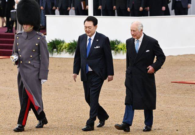 영국을 국빈 방문한 윤석열 대통령이 21일(현지시간) 런던 호스가즈 광장에서 열린 공식환영식에서 찰스 3세 영국 국왕과 왕실 근위대를 사열하기 위해 이동하고 있다. 연합뉴스