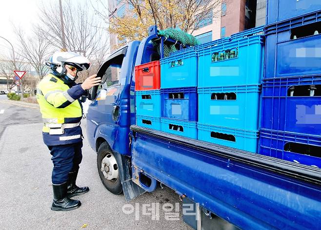 이천일 경위가 박스를 묶지 않고 운행한 주류 운반차량을 단속하고 있다.(사진=정재훈기자)