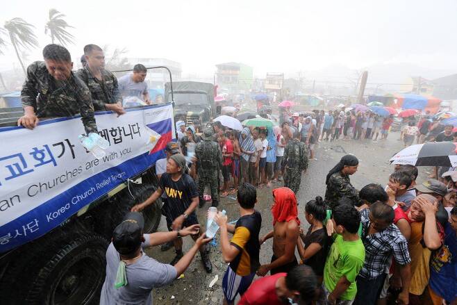 한국기독교연합봉사단이 2013년 태풍 피해를 입은 필리핀 타클로반 주민들에게 생수를 나누고 있다. 폭우가 쏟아지는데 식수는 없는 상황이었다. /한국기독교연합봉사단