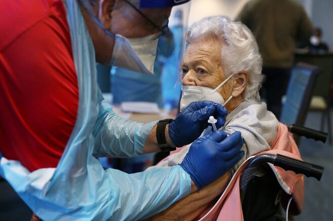 미국 플로리다의 한 요양원에서 지난 1월 90세 노인이 두 번째 코로나 백신을 맞고 있다.  /AP 연합