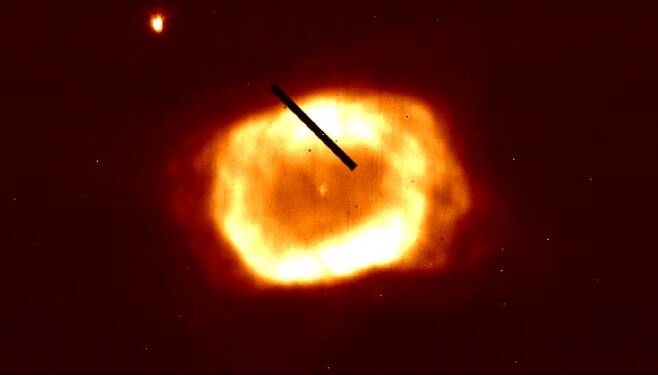 IGRINS-2 카메라로 촬영한 행성상성운 NGC 7027의 2.2마이크로미터 적외선 영상. 사진 중앙 위쪽의 검은 선이 분광기의 슬릿(파동 또는 빛의 일부만이 통과하게 만든 작은 틈)으로, 이를 통해 입사된 빛이 파장 방향으로 퍼져서 천체의 속도 성분을 알아낼 수 있다.​