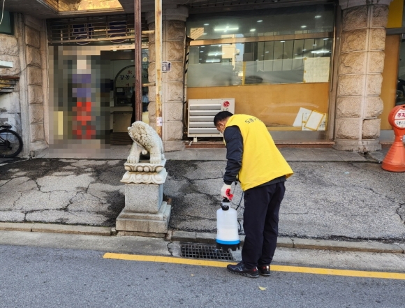 서울 도봉구 방역단이 모기가 서식하고 있는 빗물받이에 모기 유충을 없애는 약을 뿌리고 있다. 도봉구 제공