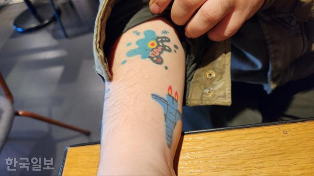 지난달 30일 서울 관악구의 한 카페에서 이씨가 팔에 새겨진 그림 문신을 내보이고 있다. 김나연 기자