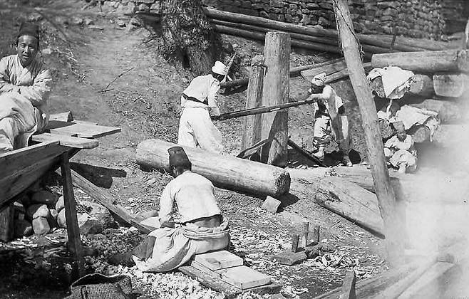 1907년 3월 조선을 방문했던 주일독일대사관 무관 헤르만 산더 일행이 촬영한 사진. 사진에는 ‘세 사람이 집을 짓는데 지키는 사람이 두 명이다’라고 적혀 있다. 조선 지하에는 화석연료인 석탄이 대량 매장돼 있었지만 일상에 투입된 동력원은 인력(人力)이었다. 생산성은 극도로 열악했다./국립민속박물관