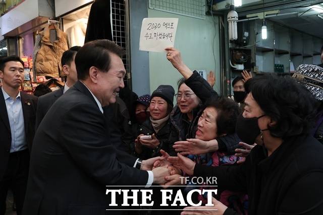 윤석열 대통령은 지난 6일 2030 세계박람회 유치 후 처음으로 부산에 내려가 국제시장을 방문했다. 윤 대통령을 향해 한 시민이 '2030 엑스포 수고하셨습니다'를 적은 종이를 들어 보이며 인사하는 모습. /대통령실 제공