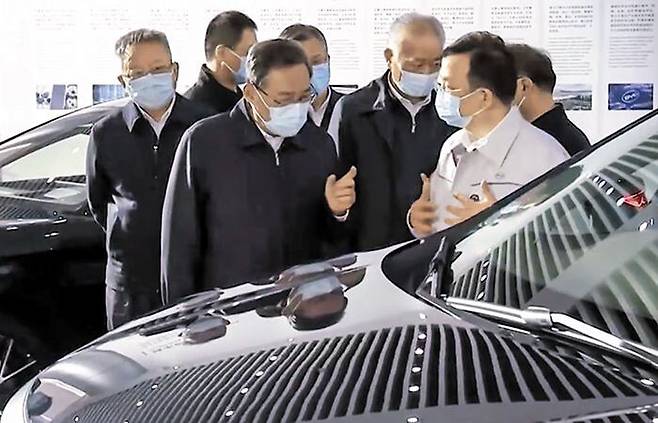 中 최대 전기차 기업 찾은 리창 - 리창(가운데) 중국 총리가 22일 중국 후난성 창사에 있는 중국 최대 전기차 기업 비야디(BYD) 전시장을 찾아 왕촨푸 BYD 회장과 이야기를 나누고 있다. /CCTV