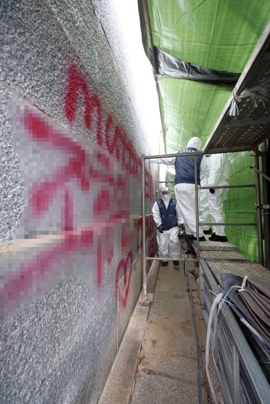 19일 오후 서울 종로구 경복궁 영추문에서 문화재청 관계자들이 스프레이 낙서로 훼손된 담벼락 복구 작업을 하고 있다. 연합뉴스