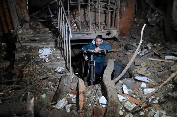 30일(현지시간) 러시아가 우크라이나 하르키우를 공격한 직후 주민이 파괴된 건물에서 자전거를 운반하고 있다. 2023.12.30 APF 연합뉴스