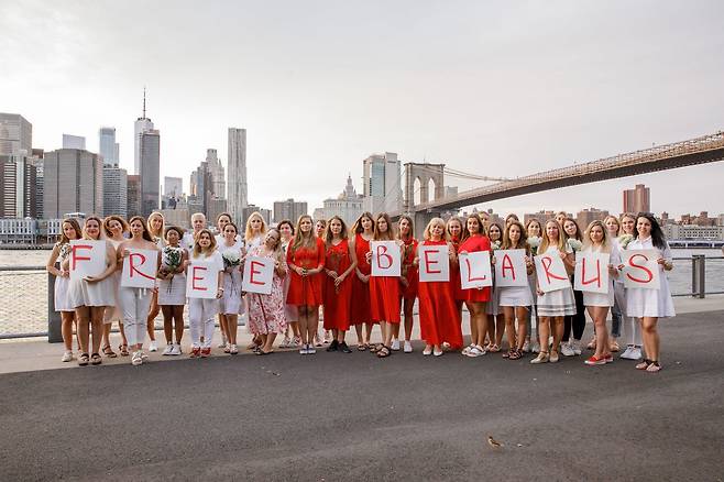 벨라루스 국기를 상징하는 흰색과 빨간색으로 옷을 입은 여성들이 시위를 벌이고 있다./트위터