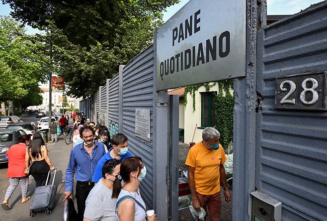 지난 6월 14일 이탈리아 밀라노의 한 무료급식소에 음식을 타려는 사람들이 줄을 서 있다./로이터