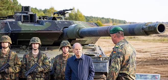 올라프 숄츠 독일 총리가 지난해 10월 독일 북부 오스텐홀츠 연방군 훈련장을 찾아 훈련 내용에 대한 설명을 듣고 있다. 숄츠 총리 뒤로 독일군 주력 탱크인 ‘레오파르트2’가 보인다. /AP 연합뉴스