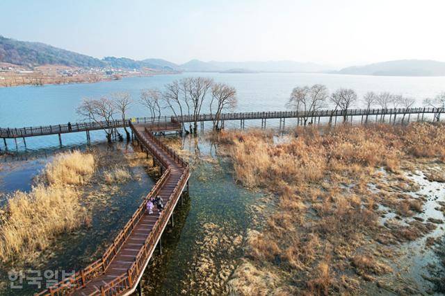 여행객들이 탑정호 수변생태공원 수상 덱을 거닐고 있다.