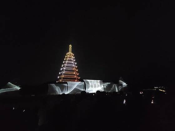 2022 익산 미륵사지 세계유산 미디어아트 페스타(총괄디렉터 이창근)에서 미륵사지 두 탑 사이에 첨단 드론 라이트쇼로 재현한 미륵사지 중원 목탑. 사진 문화기술(CT)연구소 헤리티지랩